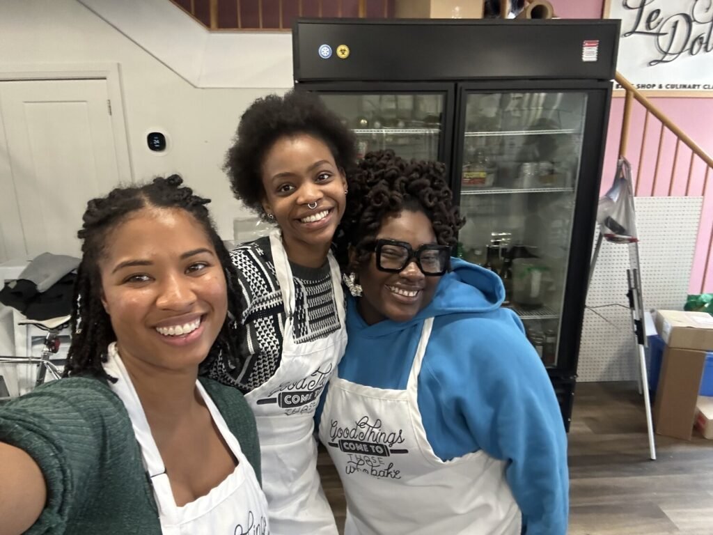 Three black women wearing cooking apparel having fun